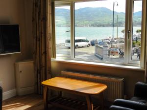 ventana con mesa y vistas al agua en Lough Álainn - Tourism NI Certified, en Warrenpoint