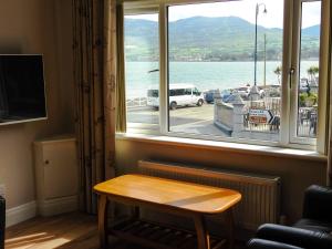 a window with a table and a view of the water at Lough Álainn - Tourism NI Certified in Warrenpoint