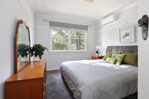 Schlafzimmer mit einem Bett, einer Kommode und einem Spiegel in der Unterkunft Pine Lodge in Blackheath