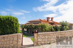 a house with a retaining wall and a stone fence at Casa de Ryvyo in Penafiel