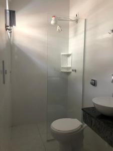 een badkamer met een douche, een toilet en een wastafel bij CASA DE PRAIA - Centro - Guaratuba in Guaratuba
