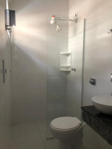 a bathroom with a shower and a toilet and a sink at CASA DE PRAIA - Centro - Guaratuba in Guaratuba