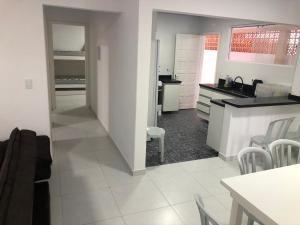 een keuken en een woonkamer met een aanrecht en een tafel bij CASA DE PRAIA - Centro - Guaratuba in Guaratuba