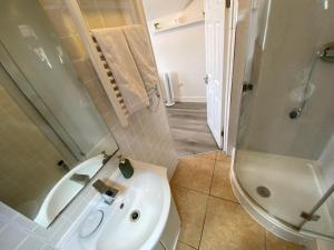 een badkamer met een witte wastafel en een douche bij Cosy flat in London in Londen