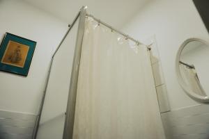 a bathroom with a shower curtain and a mirror at Hospedaje El Velero in Paracas