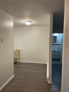 an empty room with a chair and a white wall at Norfolk Motel in Fredericton