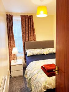 1 dormitorio con cama y ventana en Dunbar Serviced Apartment en Dunbar