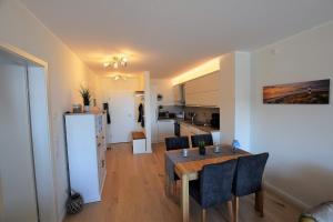 ホーヴァハトにあるMeeresblick-Strandparadies-Haus-3-WE-37のテーブルと冷蔵庫のあるキッチンとダイニングルーム