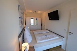 ホーヴァハトにあるMeeresblick-Strandparadies-Haus-3-WE-37のベッドとテレビのある小さな部屋