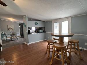 a kitchen and living room with a table and stools at Quiet Gateway close to the Marina, Beach and Base in Sneads Ferry