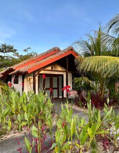 uma casa com telhado vermelho e algumas plantas em Burudika Bungalows em Selong Blanak