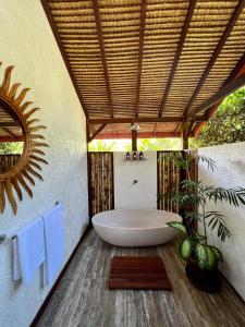 y baño con bañera y techo. en Burudika Bungalows, en Selong Belanak