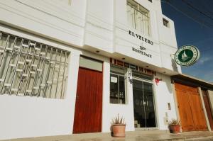 un edificio blanco con puertas rojas en una calle en Hospedaje El Velero, en Paracas