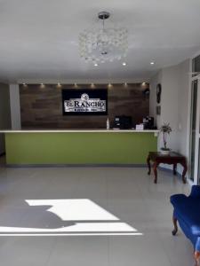 une salle d'attente avec un comptoir vert et une table dans l'établissement Hotel El Rancho, à Sabinas Hidalgo
