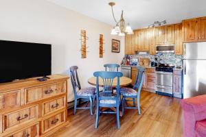 cocina con mesa y sillas y TV en Silvercreek Studio 528, en Granby