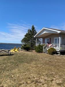 a house next to the water with a yard at Whispering Waves Cottages in Shelburne