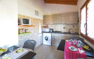 a kitchen with a table and chairs and a microwave at Beautiful Apartment In Riola Sardo With Wifi And 2 Bedrooms in Riola Sardo