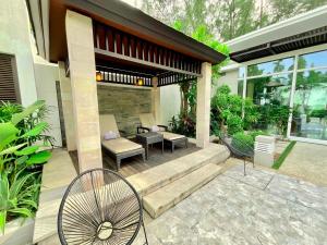 邁考海灘的住宿－Sunset Ocean Front Villa , Mai Khao Phuket，房屋设有带桌椅的庭院