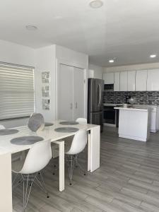 cocina con mesa, sillas y nevera en Modern Home, Excellent Location Miami, en Miami