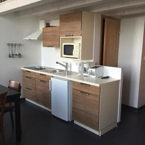 a kitchen with a sink and a microwave at Le Mole (Appartements et Chambres) in La Flotte