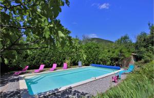 - une piscine entourée de chaises roses et bleues dans l'établissement Keyaerts, à Cliousclat