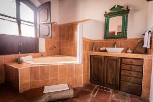 La salle de bains est pourvue d'une baignoire et d'un lavabo. dans l'établissement Hotel La Villa Serena, à Antigua Guatemala