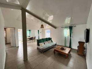 a living room with a couch and a table at La Casita Créole villa avec piscine et jacuzzi in Saint-Pierre