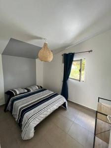Schlafzimmer mit einem Bett und einem Fenster in der Unterkunft La Casita Créole villa avec piscine et jacuzzi in Saint-Pierre