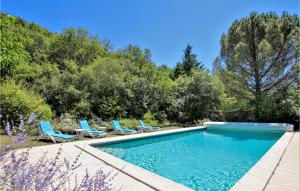 una piscina con sillas azules y árboles en Awesome Home In Curnier With Outdoor Swimming Pool, en Curnier