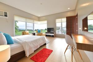 a bedroom with a large bed with a desk and a desk at One Hagdan Villas in Boracay
