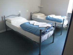 two twin beds in a room withthritisthritisthritisthritisthritisthritisthritisthritisthritis at Ostello La Mine in Cogne