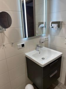 y baño con lavabo y espejo. en Gästehaus Janßen en Cuxhaven