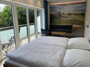 - une chambre avec un lit et une grande fenêtre dans l'établissement Gästehaus Janßen, à Cuxhaven