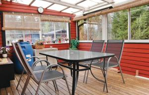 une table et des chaises noires sur une terrasse avec fenêtres dans l'établissement Nice Home In Tibro With Kitchen, à Tibro