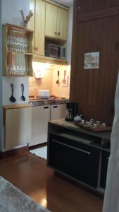 cocina con armarios de madera y encimera en Apartment Ficher Sobrinho, en Gramado