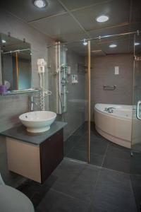 a bathroom with a shower and a sink and a tub at Showart Hotel in Taipei