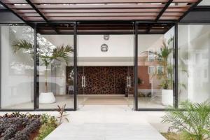 a building with large glass doors and plants at Beautiful room well located in the hotel zone of Cancun in Cancún +1 photo