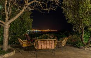 Eine Terrasse mit Stühlen und Blick auf die Stadt bei Nacht in der Unterkunft Nice Home In Kornic With House Sea View in Kornić + 27 Fotos