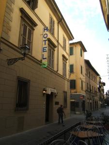 a man walking down a street in front of a building at Hotel Nuova Italia in Florence