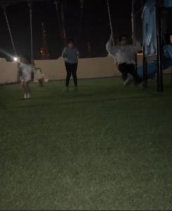 a woman and a dog playing frisbee in a park at Hotel Danat Al Khaleej in Ḩilf