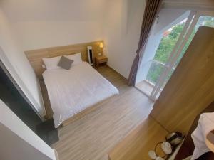 Postel nebo postele na pokoji v ubytování Lacami Dalat Hotel