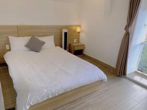 Postel nebo postele na pokoji v ubytování Lacami Dalat Hotel