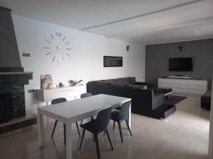 sala de estar con mesa, sillas y reloj en Villa Nour en Fez