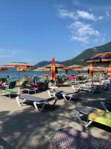 kilka leżaków i parasoli na plaży w obiekcie CLO APARTMENT w mieście Toscolano Maderno