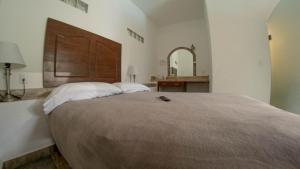a bedroom with a large bed with a large wooden headboard at La Buena Suerte in Tepoztlán