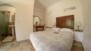 1 dormitorio con 1 cama grande y lavamanos en La Buena Suerte, en Tepoztlán