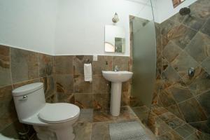 a bathroom with a toilet and a sink at La Buena Suerte in Tepoztlán