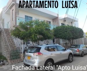 un coche plateado estacionado frente a una casa en Apartamentos LUISA, en Coveñas