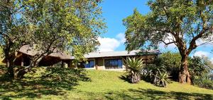 a house on a hill with trees in front of it at Wide Horizons Mountain Retreat in Malkerns