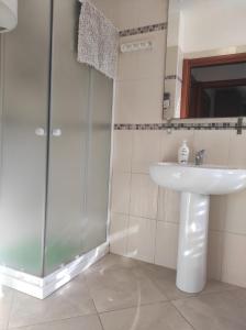 a bathroom with a sink and a glass shower at Profumo di mare in Càbras